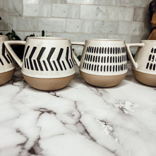 Coffee mugs with brown bottom and ivory speckled top that have dark retro designs
