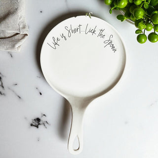 Ceramic spoon rest with baking quote displayed in modern white kitchen
Life is Short Lick the Spoon ceramic spoon holder with wooden spoon and gift tag