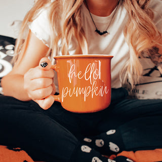 pumpkin orange mug in neutral home decor
fall work from home desk with coffee mug
orange mug and cozy socks fall aesthetic
seasonal drinkware for autumn mornings