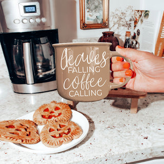 leaves falling coffee calling mug on fall tiered tray
autumn coffee mug with pumpkins and dried leaves
fall kitchen vignette with brown quote coffee cup
leaves falling coffee calling mug on rattan tray
brown autumn mug for cozy fall coffee nook
