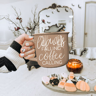 giftable autumn mug for coffee and fall leaf lovers
fall and autumn kitchen decor with brown quote mug
leaves falling coffee calling mug close up
brown fall coffee mug with autumn leaves decor
cozy autumn mug with leaves falling coffee calling phrase