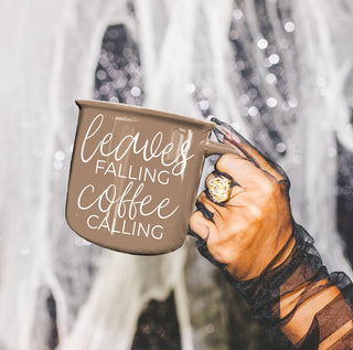 fall gift box including brown leaves falling coffee calling mug
neutral fall decor with brown coffee cup centerpiece
leaves falling coffee calling mug in modern farmhouse hutch
autumn styled shelf with brown quote mug and pumpkins