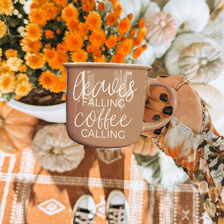 fall leaves coffee cup next to candle and pumpkin
brown cozy fall mug for autumn mornings
leaves falling coffee calling mug in halloween and fall setup
autumn gift idea brown quote coffee mug
fall themed ceramic mug with leaves and coffee phrase