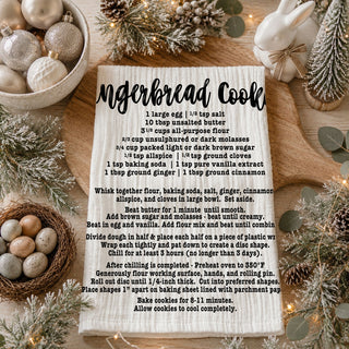 christmas kitchen towel with recipe in cozy home
holiday towel held in front of decorated christmas tree
kitchen towel recipe styled outdoor winter scene
christmas towel styled with lights and garland decor
recipe kitchen towel lifestyle holiday aesthetic