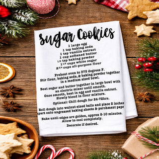 christmas kitchen towel with recipe in cozy home
holiday towel held in front of decorated christmas tree
kitchen towel recipe styled outdoor winter scene
christmas towel styled with lights and garland decor
recipe kitchen towel lifestyle holiday aesthetic