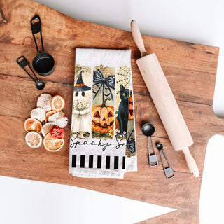 black and white striped halloween towel with ghost panel
spooky season tea towel for black cat lovers
unique halloween gift towel with ghost and grave illustration
spooky season dish towel draped over oven handle