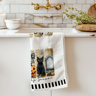 neutral halloween kitchen towel with modern spooky illustrations
ghost pumpkin spiderweb towel hanging on oven handle
stylish halloween tea towel with black cat grave and pumpkins
spooky season bar cart towel with ghost and jack o lantern