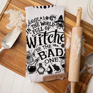 in a world full of witches be the bad one towel on cutting board
snarky witch kitchen décor towel for spooky season
witchcore kitchen towel with broom moon and potion illustrations